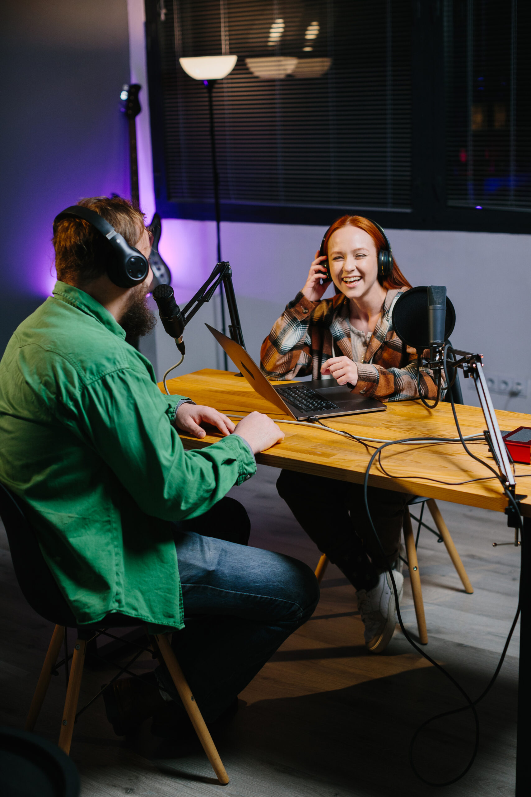 a podcast host and a guest have fun chatting during a live online broadcast in a home studio.